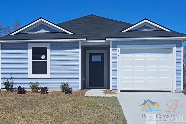 A blue house with a white garage door and a black door.