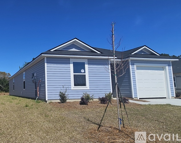 A blue house with a white garage door is for sale.