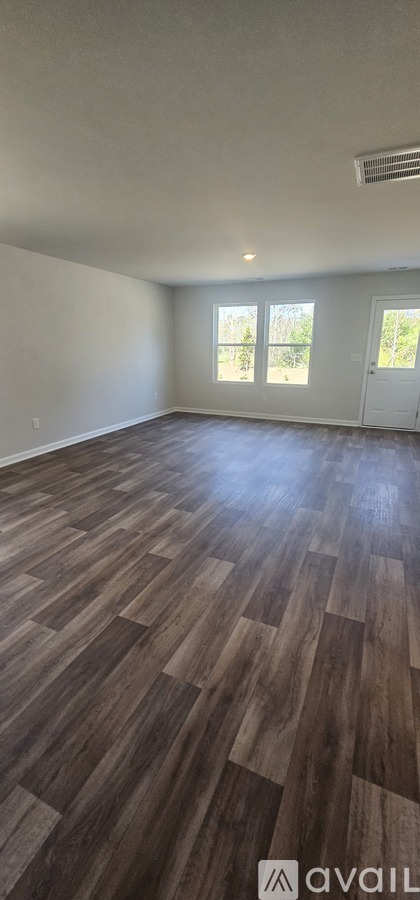 A room with wooden flooring and a door.