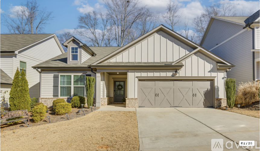 A house with a grey garage door and a driveway.