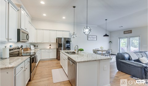 A modern kitchen with white cabinets and a large island.