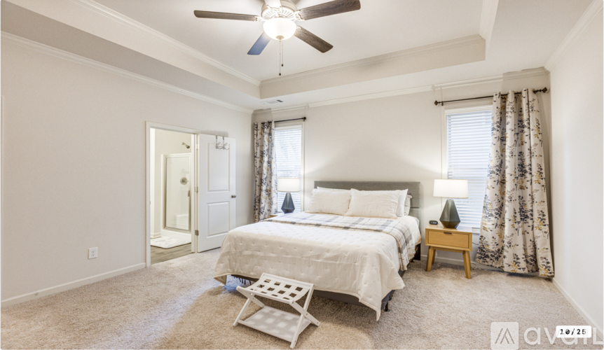 A bedroom with a bed, nightstand, and chair.