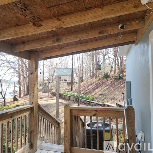 A wooden deck with a view of a backyard and trees.