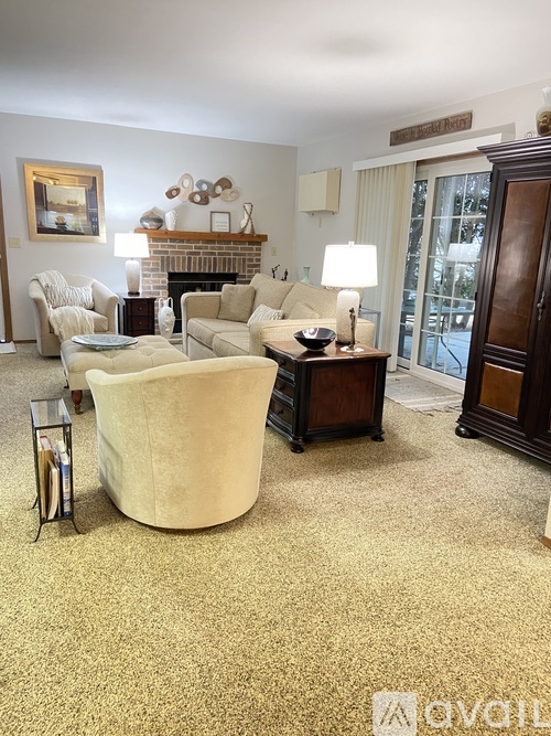A living room with a beige sofa, a coffee table, and a fireplace.
