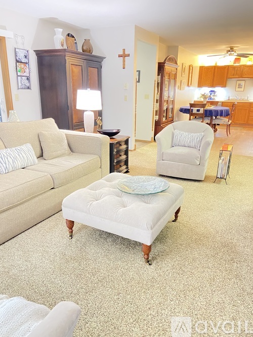 A living room with a couch, chair, and ottoman.