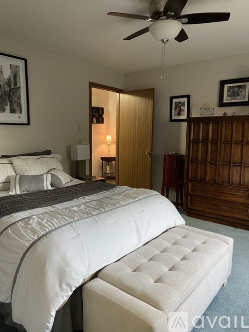 A bedroom with a large bed and a ceiling fan.