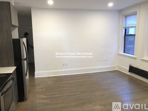 A kitchen with a refrigerator and a window.