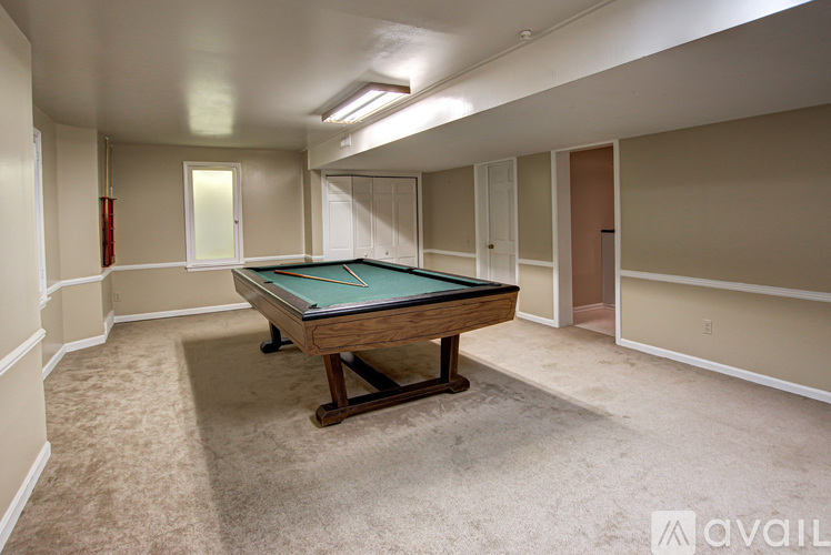 A pool table in a room with beige walls and carpet.