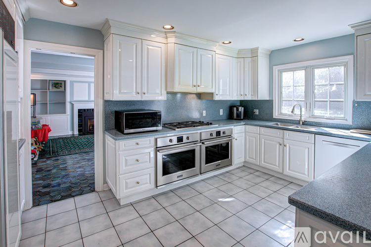 A kitchen with white cabinets and a black countertop.