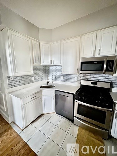 A kitchen with white cabinets and a black stove top oven.