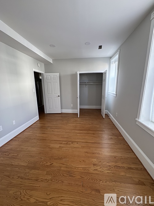 A room with wooden flooring and white walls.