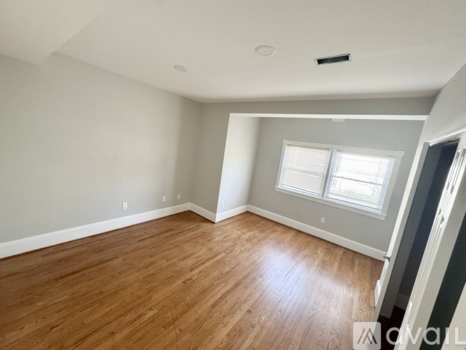 A room with wooden flooring and a window.