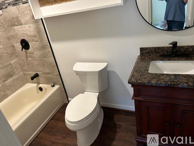 A white toilet sits next to a bathtub in a bathroom.