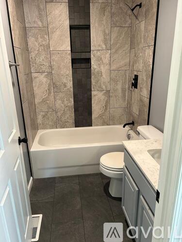A bathroom with a tub, toilet, and sink.