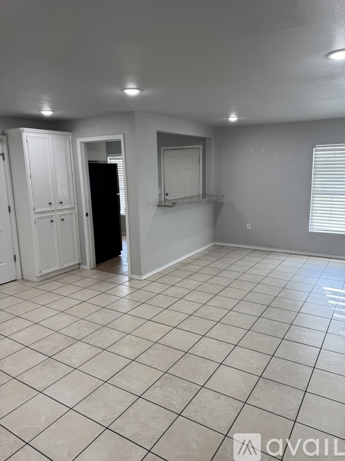 A room with white tiled flooring and white walls.