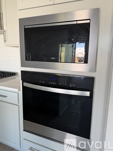 A modern kitchen with a stainless steel oven and microwave.