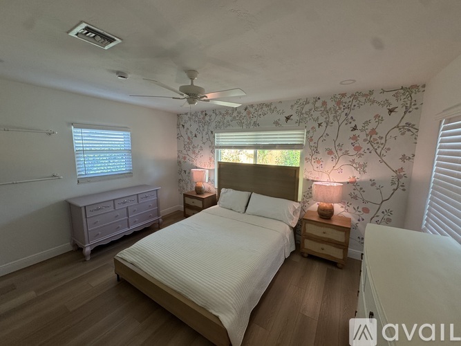 A bedroom with a bed, dresser, and window.