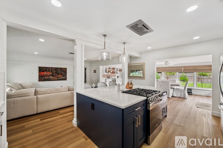 A modern kitchen with dark blue cabinets and a white island.