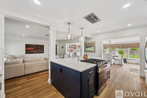 A modern kitchen with dark blue cabinets and a white island.
