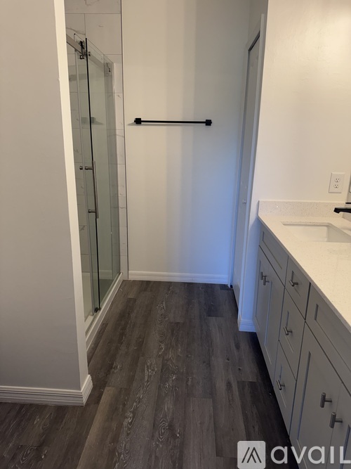 A bathroom with a glass shower door and a white sink.