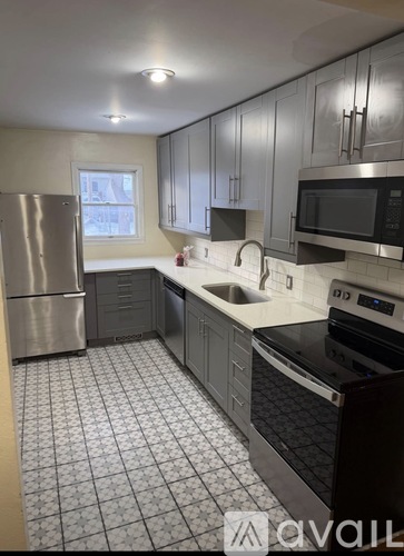 A kitchen with a black and white tiled floor.