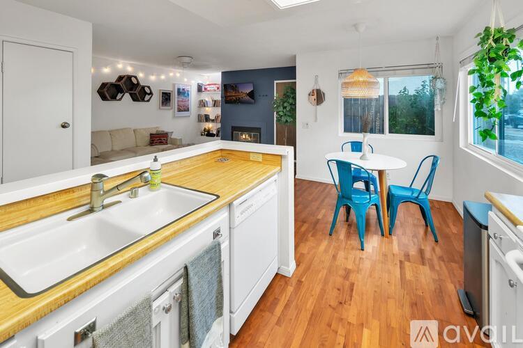 A kitchen with a white sink and blue chairs.