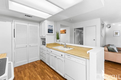 A kitchen with a white sink and blue chairs.