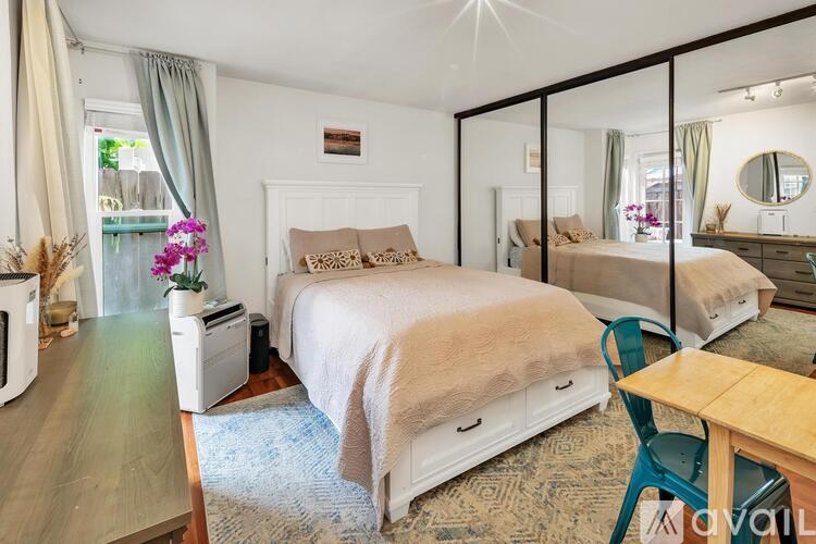 A bedroom with a large bed and a mirror on the wall.