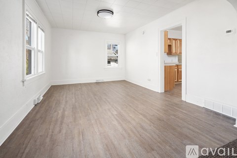 A room with a carpeted floor and a window with white blinds.