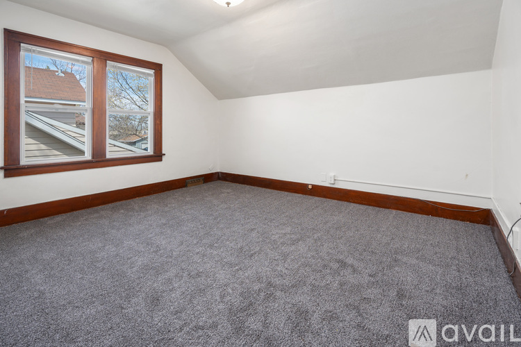 A kitchen with wooden cabinets and a window with snow outside.