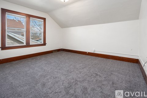 A kitchen with wooden cabinets and a window with snow outside.