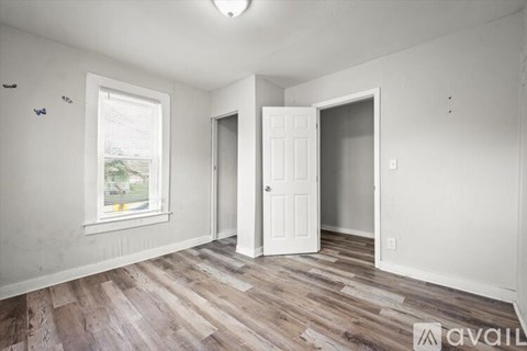 A room with a window and wooden flooring is available for rent.