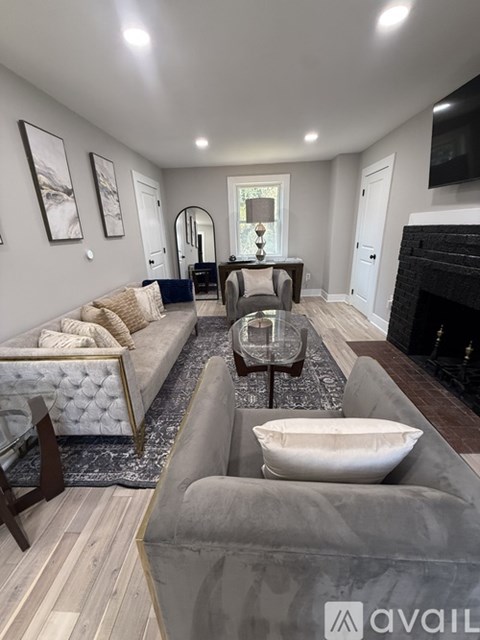 A modern living room with a grey sofa and a fireplace.