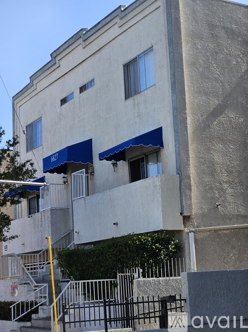 A building with a blue awning and a staircase leading to the entrance.