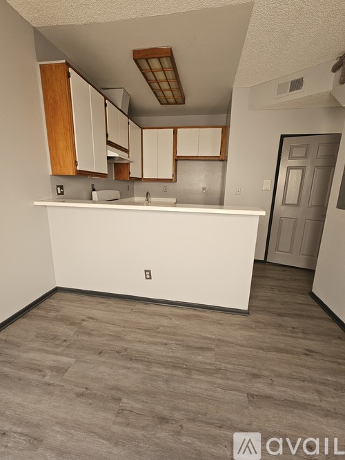 A kitchen with white countertops and wooden cabinets.