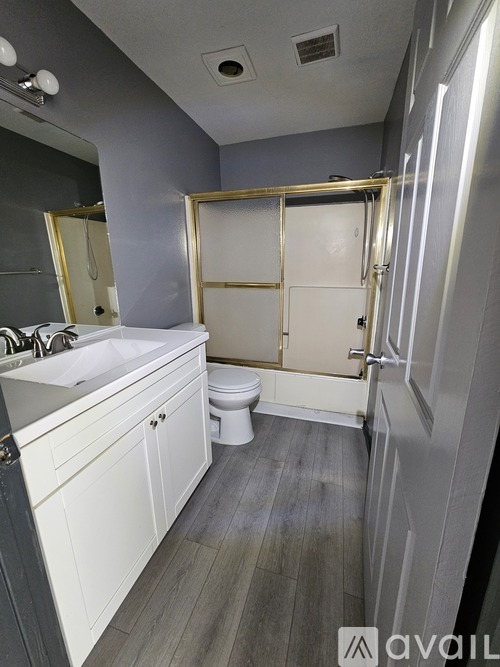 A bathroom with a white toilet, sink, and a walk-in shower.