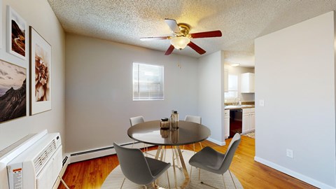 A dining room with a table and chairs.