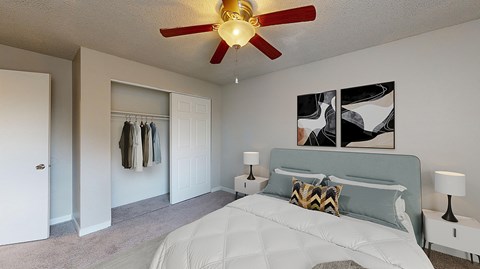 A bedroom with a large bed and a ceiling fan.