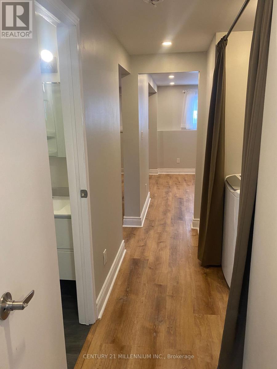 A hallway with wood floors and white walls.