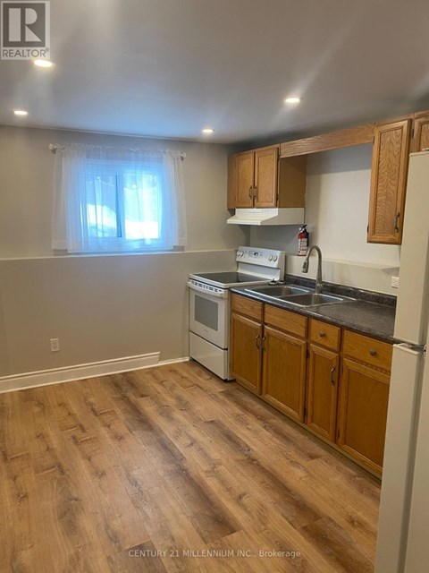 A kitchen with wooden floors and a white stove top oven.