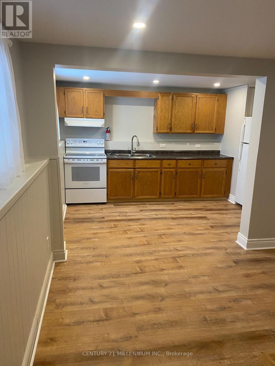 A kitchen with wooden floors and cabinets.
