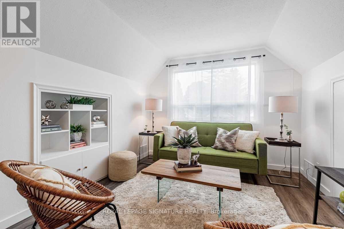 A living room with a green couch, a wicker chair, and a wooden coffee table.