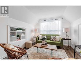 A living room with a green couch, a wicker chair, and a wooden coffee table.