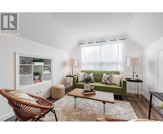 A living room with a green couch, a wicker chair, and a wooden coffee table.