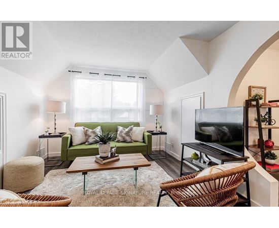 A living room with a green couch and a television.