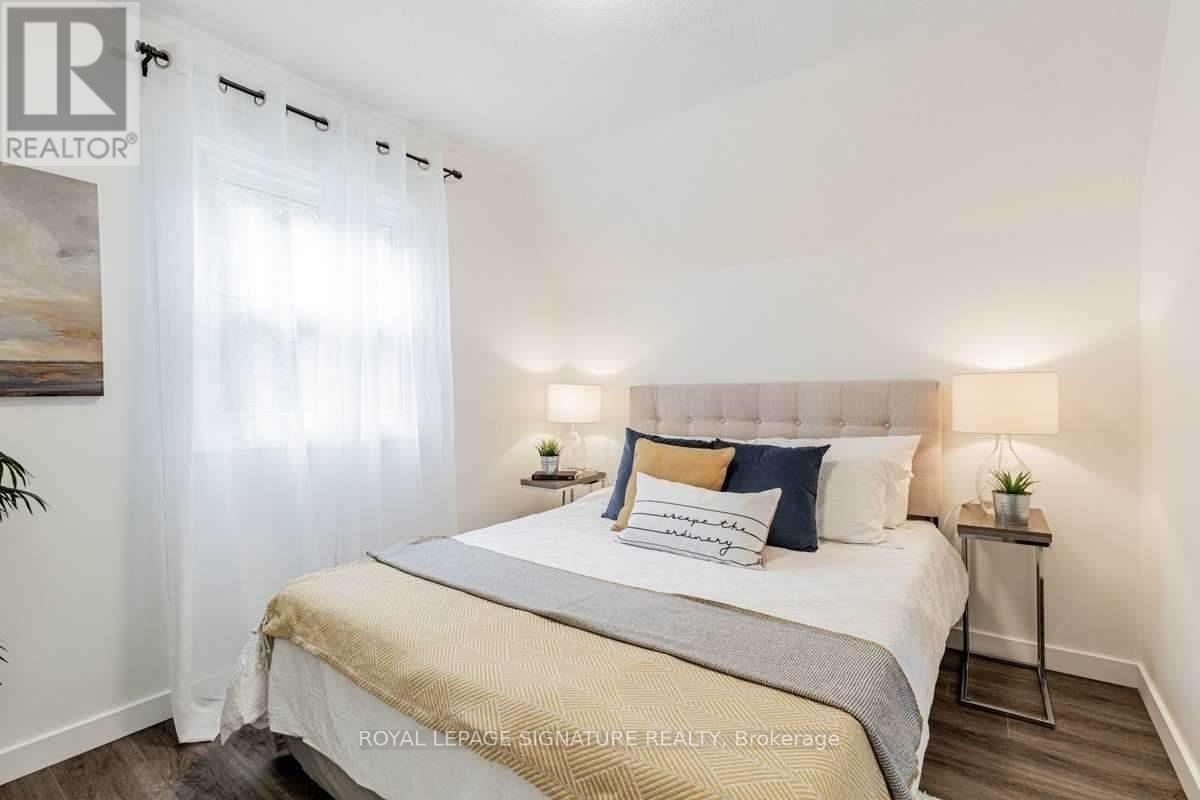 A bedroom with a large bed and a painting on the wall.