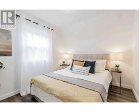 A bedroom with a large bed and a painting on the wall.
