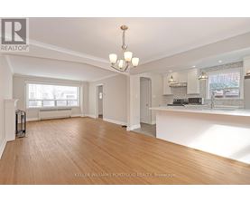 A spacious living room with hardwood floors and a large window.