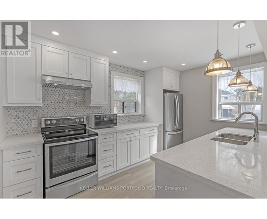 A modern kitchen with white cabinets and stainless steel appliances.