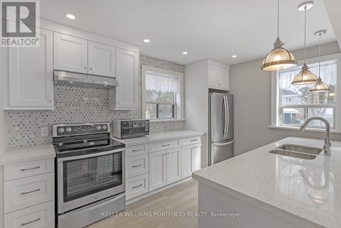 A modern kitchen with white cabinets and stainless steel appliances.